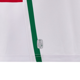 A close-up of a white fabric featuring vertical green and red stripes, reminiscent of the classic Wales 24/25 6 Nations Replica Away Jersey by Macron. There is an eco-friendly label near the bottom center, emphasizing sustainable craftsmanship.