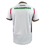 The Wales 24/25 6 Nations Replica Away Jersey by Macron displays a back view accented with red and green details. The phrase "GO.COMPARE" is elegantly printed in green on the upper back, while the embossed design on the lower back highlights sporty elegance.
