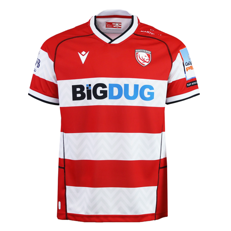 The Gloucester 25/26 Replica Home Jersey by Macron features red and white stripes, sponsor logos, black-trimmed sleeves, and the iconic club crest—official home design from Macron.