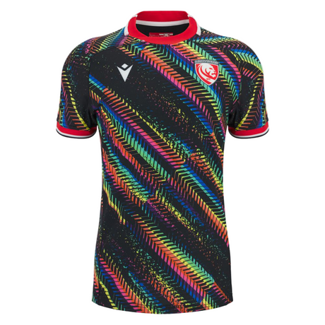The Gloucester 25/26 Replica Training Jersey by Macron is a black sports jersey with multicolored diagonal patterns and a red and white crest on the left chest.