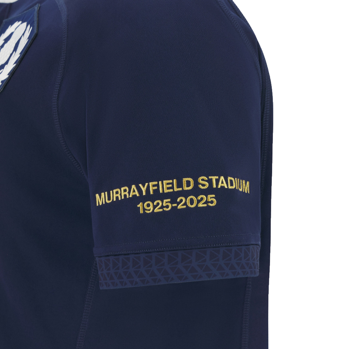 Close-up of the Macron Scotland Rugby Union 1925 100th Anniversary Replica Home Jersey sleeve, featuring yellow "Murrayfield Stadium 1925-2025" text and a geometric pattern, celebrating the stadium’s centenary.