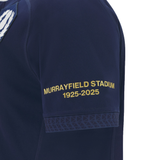Close-up of the Macron Scotland Rugby Union 1925 100th Anniversary Replica Home Jersey sleeve, featuring yellow "Murrayfield Stadium 1925-2025" text and a geometric pattern, celebrating the stadium’s centenary.