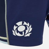 A close-up of blue textured athletic fabric from the Scotland SRU 26/27 Matchday Home Shorts by Macron, featuring a white Scottish Rugby thistle emblem and a reinforced vertical seam with contrast stitching, highlighting the premium craftsmanship of these authentic Macron rugby shorts.