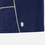 Close-up of a dark blue fabric with light stitching, featuring a subtle pattern and a Macron label near the hem against a white background, reminiscent of the premium craftsmanship found in the Scotland SRU 26/27 Replica Home Jersey by Macron.