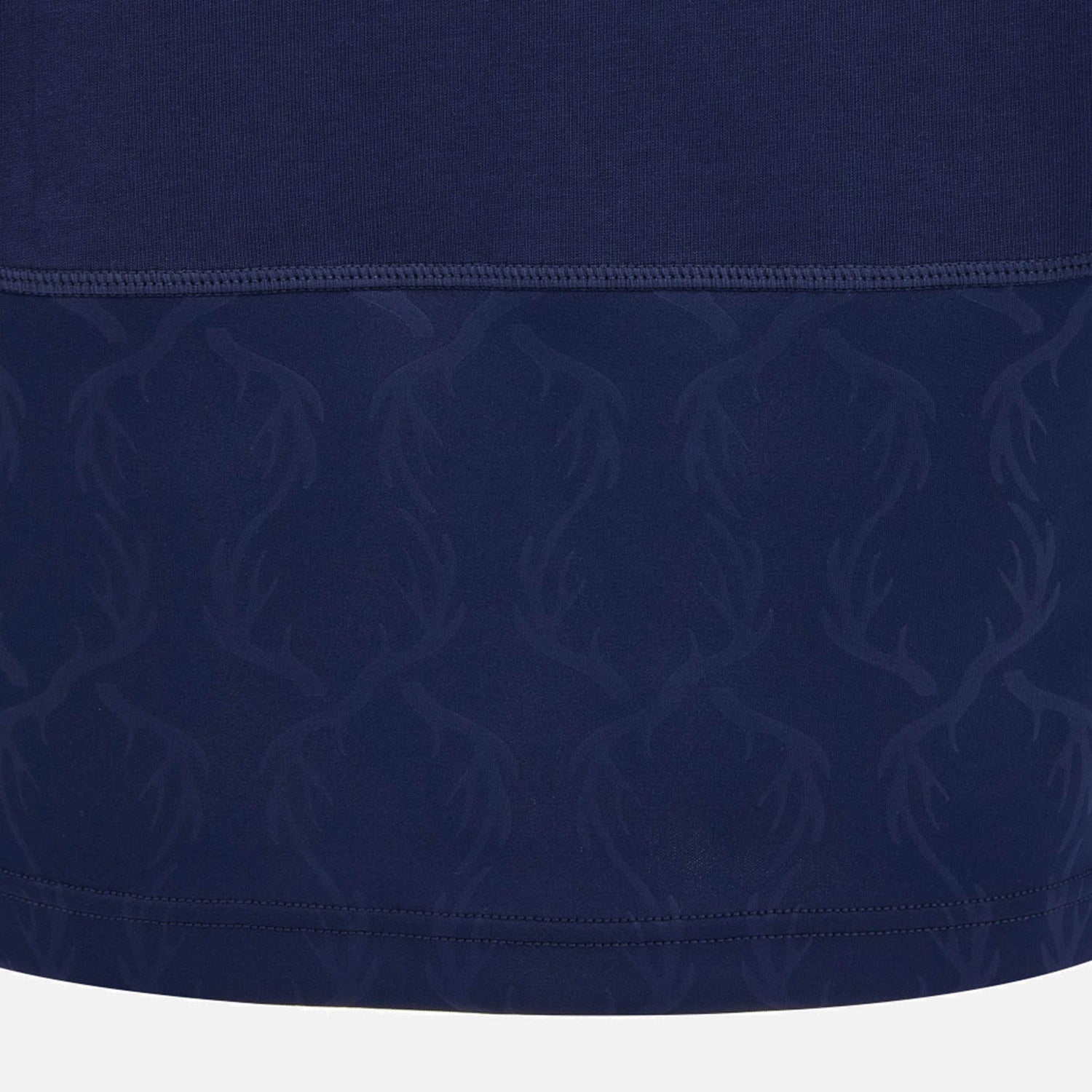 Crafted by Macron, the Scotland SRU 26/27 Cotton Replica Long Sleeve Home Jersey features dark blue fabric with a subtle, repeating antler pattern on the lower section and a visible seam separating two distinctive textures, inspired by the classic Scotland rugby jersey design.