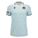 The Scotland SRU 26/27 Replica Training Jersey by Macron features a light blue base with dark blue trim, a distinctive cracked pattern design, and a V-neck. This replica training jersey showcases Scotland and sponsor logos on the chest and sleeve.