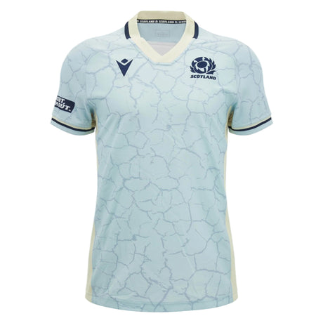 The Scotland SRU 26/27 Replica Training Jersey by Macron features a light blue base with dark blue trim, a distinctive cracked pattern design, and a V-neck. This replica training jersey showcases Scotland and sponsor logos on the chest and sleeve.