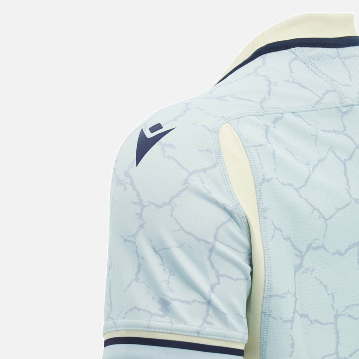 Close-up of the Scotland SRU 26/27 Replica Training Jersey by Macron in light blue, featuring a cracked pattern, dark Macron logo on the shoulder, and cream accents along the sleeve and collar, set against a plain background. Designed for both fans and athletes, this training jersey seamlessly combines style with high-performance features.