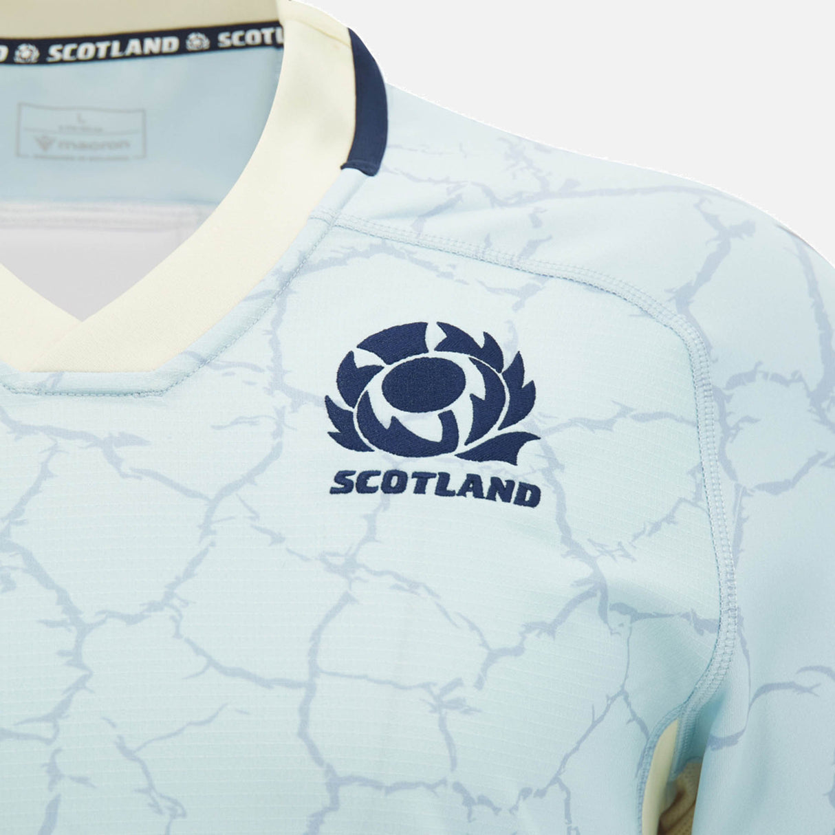 The Scotland SRU 26/27 Replica Training Jersey by Macron showcases a light blue design with an abstract crackle pattern, accented by a navy logo and white collar trim—making it the ideal replica training jersey for committed Scotland Rugby fans.