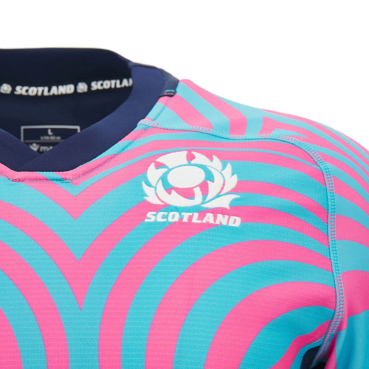 Get a close-up view of the Scotland SRU 26/27 Replica Training Jersey by Macron, showcasing bold pink and teal wavy stripes along with the Scotland logo and text on the chest. This jersey from Macron perfectly blends modern style with team pride.