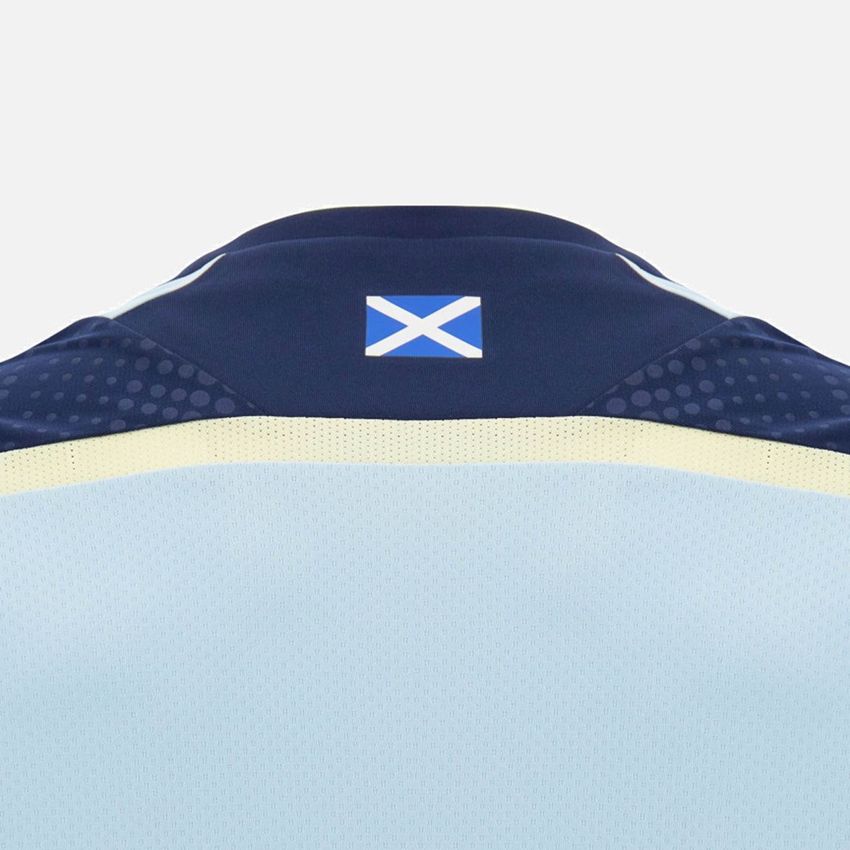 Back of the Scotland SRU 26/27 Player Training Shirt by Macron, featuring a small Scottish flag on the collar. The light blue jersey, made by Macron, showcases classic navy and yellow accents on a plain background—reflecting the iconic style of an official Scotland Rugby training shirt.