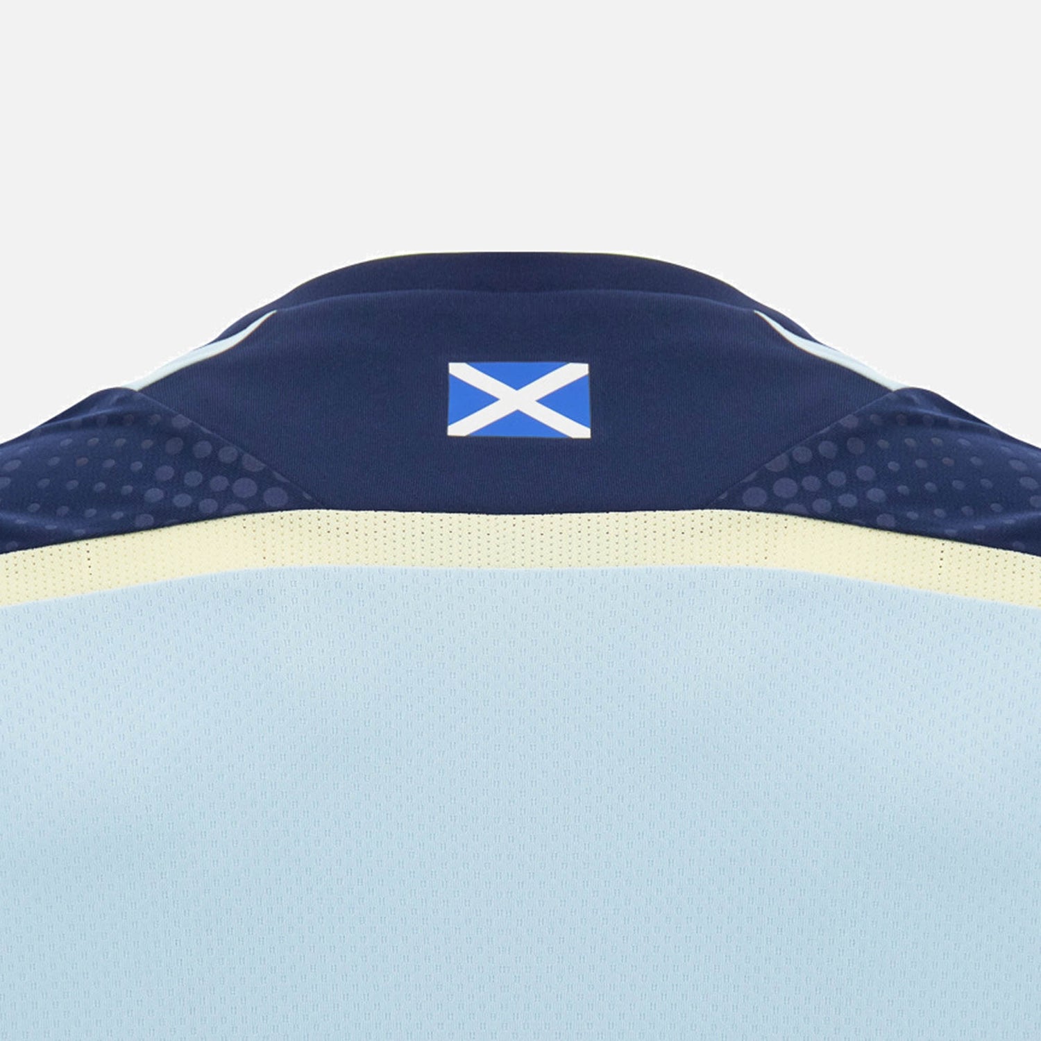 Back of the Scotland SRU 26/27 Player Training Shirt by Macron, featuring a small Scottish flag on the collar. The light blue jersey, made by Macron, showcases classic navy and yellow accents on a plain background—reflecting the iconic style of an official Scotland Rugby training shirt.