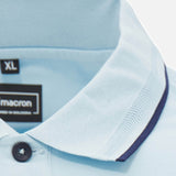 Close-up of the Scotland SRU 26/27 Travel Polo by Macron in light blue, featuring a collared design with a dark blue trim along the edge and a black size XL label.