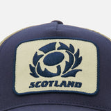 Close-up of the Scotland SRU 26/27 Trucker Cap by Macron, featuring a patch with a stylized rugby ball logo and "Scotland" embroidered in blue.