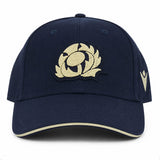 The Scotland SRU 26/27 Thistle Baseball Cap by Macron features a navy blue design with a cream embroidered thistle logo on the front and a cream stripe on the brim.