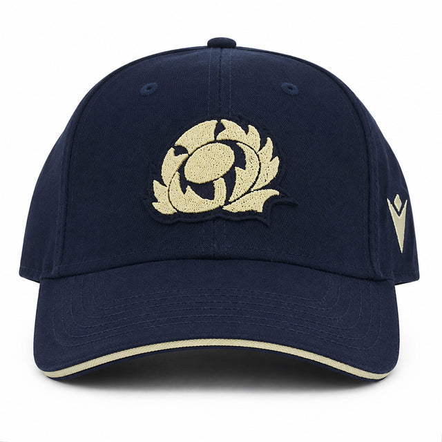The Scotland SRU 26/27 Thistle Baseball Cap by Macron features a navy blue design with a cream embroidered thistle logo on the front and a cream stripe on the brim.