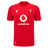 The Wales WRU 26/27 Replica Home Jersey by Macron is a red short-sleeve rugby shirt featuring the white Vodafone logo, WRU crest, and Macron branding on the front. Part of the official Macron 26/27 collection, this replica jersey is perfect for supporters looking to show their pride.