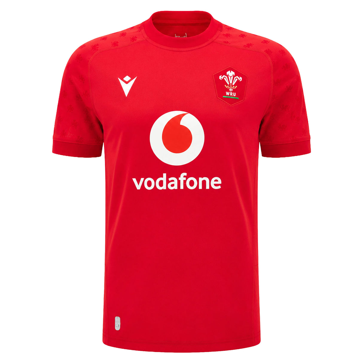 The Wales WRU 26/27 Replica Home Jersey by Macron is a red short-sleeve rugby shirt featuring the white Vodafone logo, WRU crest, and Macron branding on the front. Part of the official Macron 26/27 collection, this replica jersey is perfect for supporters looking to show their pride.