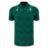 Wales WRU 26/27 Travel Poly Polo by Macron in green, featuring black shoulder accents, white chest logos, and a subtle checkered pattern.