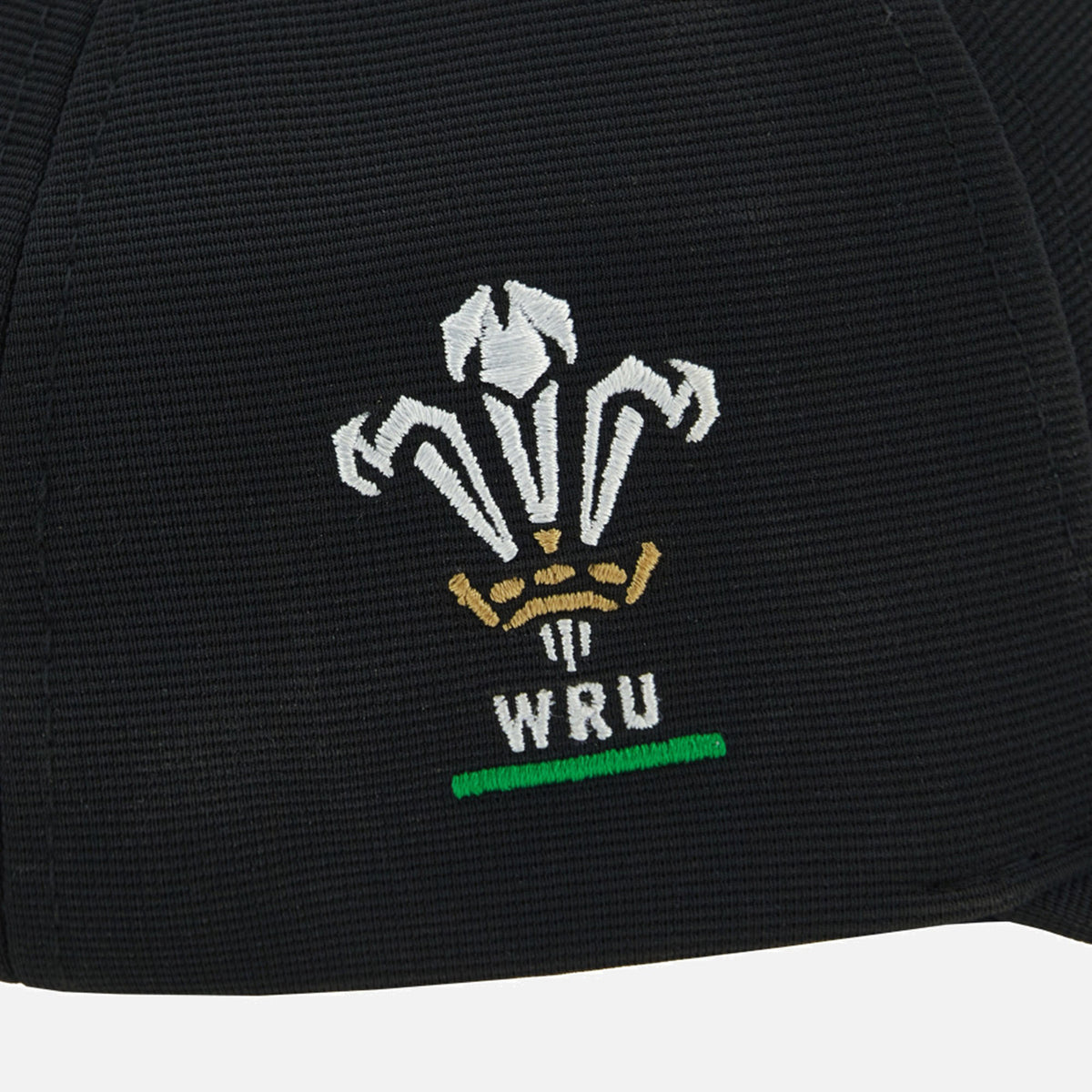 Show your support for Welsh rugby with the Wales WRU 26/27 Baseball Cap by Macron—a classic black cap featuring an embroidered white and gold Welsh Rugby Union (WRU) logo with three feathers, a crown, and a green underline, perfect for passionate rugby fans.