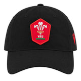 The Wales WRU 26/27 Dad Cap by Macron is a black cap featuring a red patch with the Welsh Rugby Union (WRU) logo—three feathers and “WRU” text—on the front. This stylish Macron cap is perfect for any supporter wanting to show their passion for Welsh rugby.