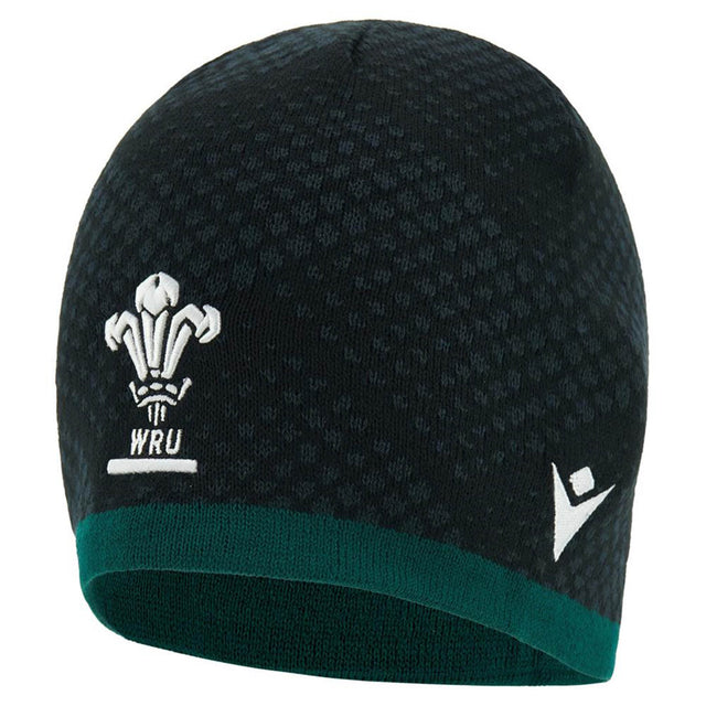 The Wales WRU 26/27 Knit Beanie by Macron features a black and green knit design with the iconic Welsh Rugby Union logo and a white Macron brand logo on the front.