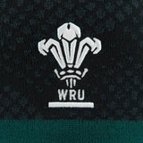 Embroidered white WRU logo with three feathers stands out on the dark, patterned fabric background, highlighting the distinctive style of the official Wales WRU 26/27 Knit Beanie by Macron.