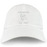 The Amoskeag Rugby Club Adult Low-Profile Cotton Twill Dad Cap by EMB S&S Activewear is a white dad cap featuring an embroidered outline ram's head and "AMOSKEAG Est. 1984" on the front.