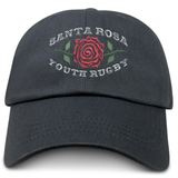 The EMB S&S Activewear Santa Rosa Youth Rugby Adult Low-Profile Cotton Twill Dad Cap is a black cotton twill hat with embroidered “Santa Rosa Youth Rugby” and a red rose graphic on the front.