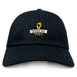 The EMB S&S Activewear Chicago Riot Adult Low-Profile Cotton Twill Dad Cap features yellow and white embroidered "Chicago Riot Rugby Football Club" branding on the front.