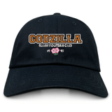 Introducing the Godzilla Rugby Football Club Adult Low-Profile Cotton Twill Dad Cap by EMB S&S Activewear—a black cotton twill hat featuring bold gold and white “GODZILLA RUGBY FOOTBALL CLUB” embroidery, a pink flower, and “19 93” displayed on the front for standout team branding.