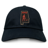 An Aging Alabama Rugby Players Adult Low-Profile Cotton Twill Dad Cap by EMB S&S Activewear featuring an embroidered design of the state of Alabama, a figure with a scythe, and the word “HARD” in a gothic font.
