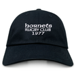 The Hornets Rugby Club 1977 Adult Low-Profile Cotton Twill Dad Cap by EMB S&S Activewear features black cotton twill and white embroidered "hornets RUGBY CLUB 1977" team branding on the front.