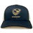 The USA Rugby Bronze Eco Trucker Hat by EMB S&S Activewear features navy blue and white organic cotton with the USA Rugby logo and "USARUGBY" printed on the front.