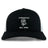 The Amoskeag Rugby Club Retro Trucker Cap by EMB S&S Activewear features black and white panels, an embroidered "AMOSKEAG," bold ram logo, "Est. 1984," and a classic snapback closure.
