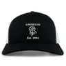 The Amoskeag Rugby Club Retro Trucker Cap by EMB S&S Activewear features black and white panels, an embroidered "AMOSKEAG," bold ram logo, "Est. 1984," and a classic snapback closure.