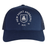 Introducing the New Saint Andrews College Retro Trucker Cap by EMB S&S Activewear. This navy blue cap features a classic mesh back and showcases an embroidered white New Saint Andrews RFC logo with “1994” printed on the front panel. The adjustable snapback closure ensures a comfortable fit.