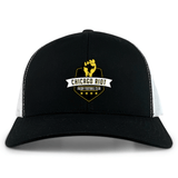 The Chicago Riot Retro Trucker Cap by EMB S&S Activewear is a black and white trucker hat with a yellow and white embroidered "Chicago Riot Rugby Football Club" design, raised fist, four stars, and an adjustable snapback closure.