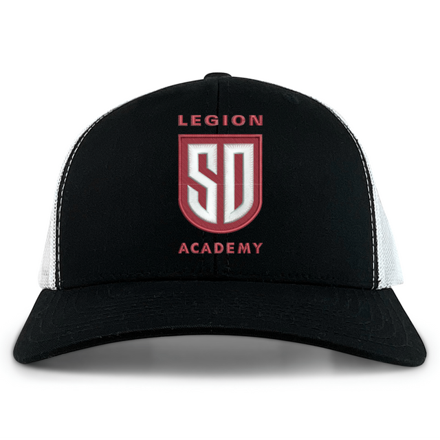 Legion Academy Retro Trucker Cap in black and white featuring an embroidered red and white “Legion Academy SD” shield emblem on the front with a snapback closure.