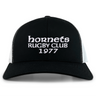 The Hornets Rugby Club 1977 Retro Trucker Cap by EMB S&S Activewear features an embroidered "hornets RUGBY CLUB 1977" design on the front, classic black and white color styling, and a comfortable snapback closure for an adjustable fit.