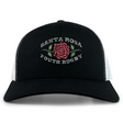 The EMB S&S Activewear Santa Rosa Youth Rugby Retro Trucker Cap is a black and white trucker cap with a red rose and green leaves, featuring “Santa Rosa Youth Rugby” embroidered on the front.