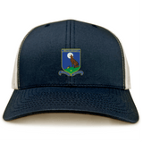 The Media Rugby Retro Trucker Cap by EMB S&S Activewear is a navy and white trucker hat with an embroidered crest showcasing a bear, rugby ball, and "Honour. Dignity. Respect." phrase, plus an adjustable snapback closure for fit.