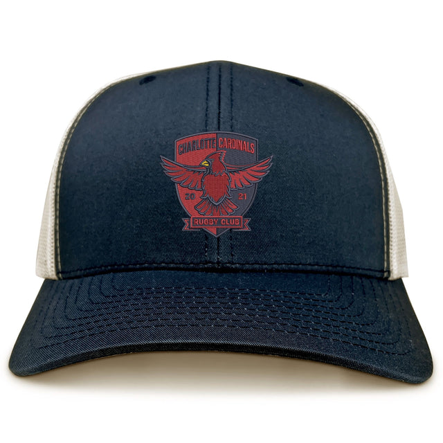 The Charlotte Cardinals Retro Trucker Cap by EMB S&S Activewear features navy blue and white panels, a red eagle logo, "Charlotte Cardinals Rugby Club 2021" on the front, retro trucker design, and adjustable snapback closure.