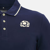 Close-up of the Scotland SRU 26/27 Travel Polo by Macron in navy, featuring cream buttons and a white rugby thistle emblem on the left chest.