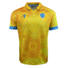 The Uruguay 24/25 Replica Away Jersey by Macron is a yellow and orange rugby jersey, accented with blue trim and collar, featuring sun motifs, a blue crest with a bird and "URU" text, crafted from Eco Fightex stretch fabric.