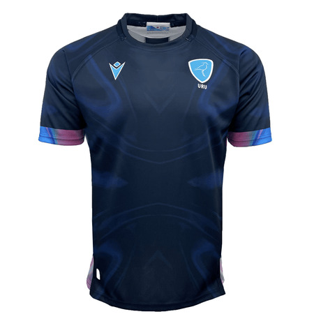 The Uruguay 24/25 Replica Training Jersey by Macron features a dark blue athletic design with a light blue and white logo showcasing a bird and the letters "URU" on the left chest. The sleeves are accented with purple and blue near the cuffs, making it an official Uruguay Rugby jersey for 2024/25.