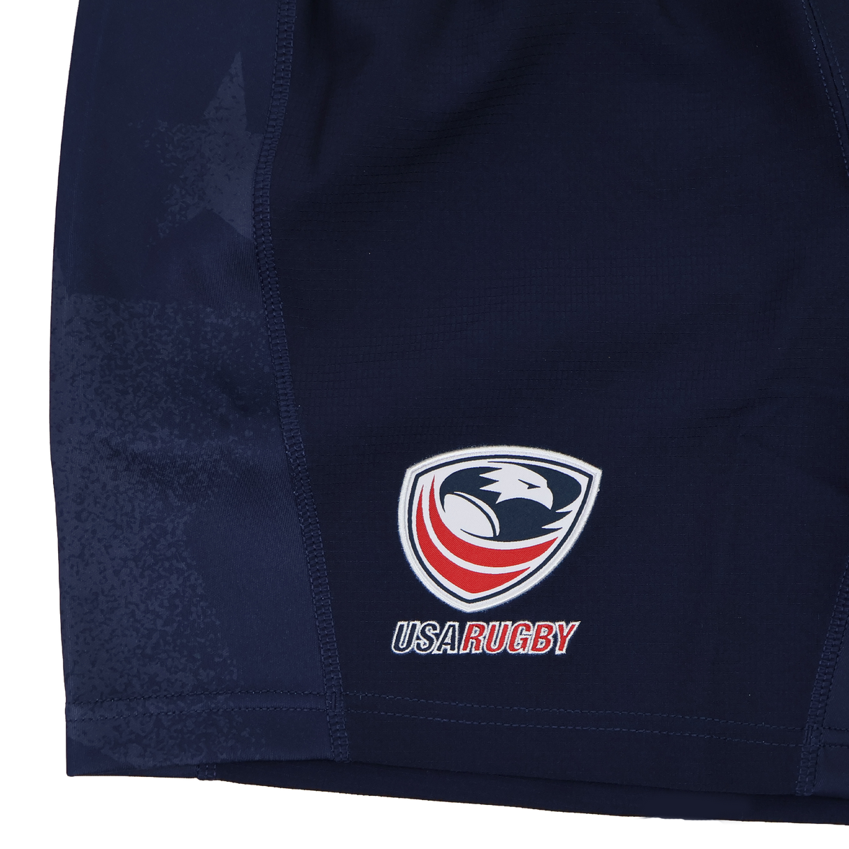 Close-up of USA Rugby 24/25 Home Shorts by Macron in navy blue, featuring moisture-wicking fabric and the USA Rugby eagle logo with "USA Rugby" text on the lower left side.