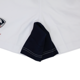 Close-up of the hem and side seam of USA Rugby 24/25 Matchday Away Shorts by Macron, featuring a navy blue gusset and visible stitching for rugby performance.