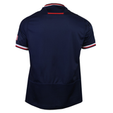 The USA Rugby 25/26 Replica Home Jersey by Macron, shown from the back, features navy-blue fabric, red, white, and blue trim on the collar and sleeves, plus an American flag patch—ideal for USA Rugby fans.