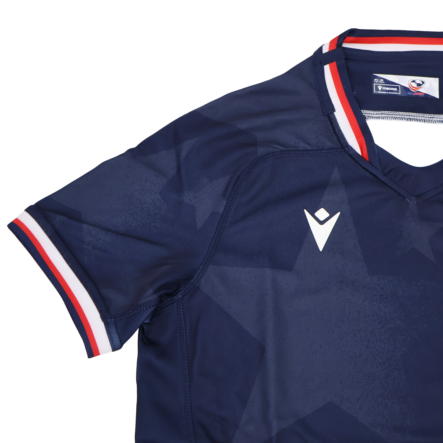 The Youth USA Rugby 24/25 Home Jersey by Macron features a navy blue design with a subtle star pattern, white Macron logo, and red, white, and blue trim—perfect for young fans of the USA Rugby style.